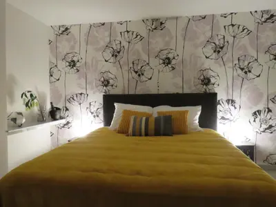 a bedroom with a yellow bed with a floral wall at Kitrino in Geel