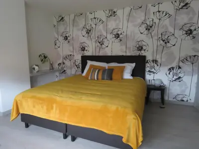 a bedroom with a large bed with a yellow blanket at Kitrino in Geel