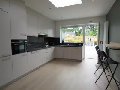 a kitchen with white cabinets and a large window at Kitrino in Geel