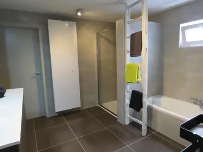a bathroom with a shower and a tub and a sink at Kitrino in Geel