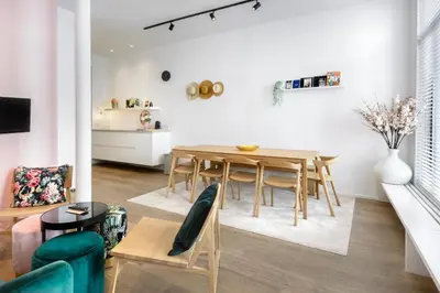 a living room with a dining room table and a kitchen at The 1880 Boutique Holiday Home in Antwerp
