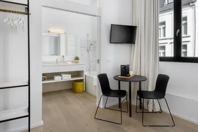 a room with a table and chairs and a sink at The 1880 Boutique Holiday Home in Antwerp