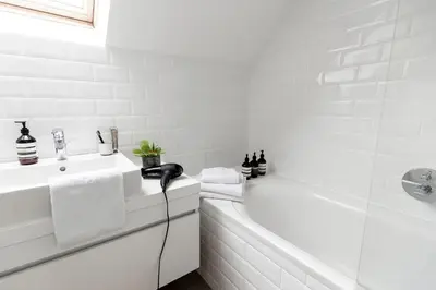 a white bathroom with a tub and a sink at The 1880 Boutique Holiday Home in Antwerp