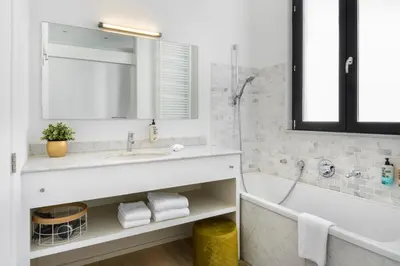 a bathroom with a sink and a tub and a mirror at The 1880 Boutique Holiday Home in Antwerp