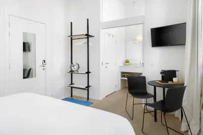 a bedroom with a bed and a table and chairs at The 1880 Boutique Holiday Home in Antwerp