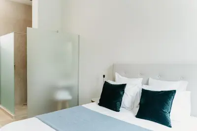 a bedroom with a bed with green and white pillows at The 1880 Residence by Domani Hotels in Antwerp