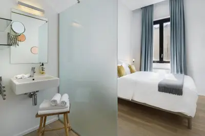 a bathroom with a bed and a sink and a mirror at The 1880 Residence by Domani Hotels in Antwerp