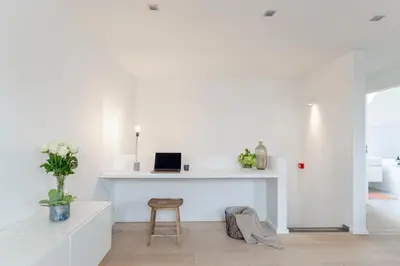a white room with a desk with a laptop on it at The 1880 Residence by Domani Hotels in Antwerp
