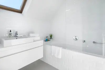a white bathroom with a tub and a sink at The 1880 Residence by Domani Hotels in Antwerp