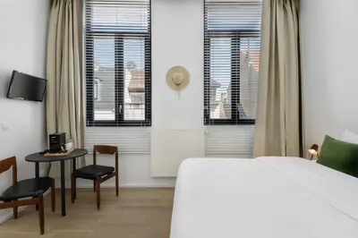 a bedroom with a bed and a table and chairs at The 1880 Residence by Domani Hotels in Antwerp