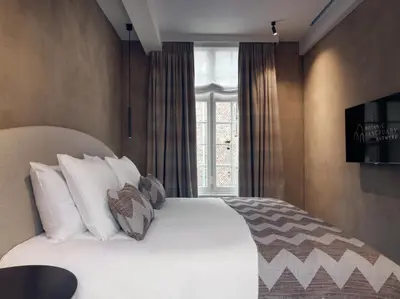 a bedroom with a bed with white pillows and a window at Botanic Sanctuary Antwerp - The Leading Hotels of the World in Antwerp
