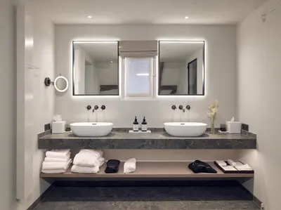 two sinks in a bathroom with two mirrors and towels at Botanic Sanctuary Antwerp - The Leading Hotels of the World in Antwerp