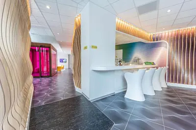 a lobby with a row of white chairs and a counter at Prize by Radisson, Antwerp City in Antwerp