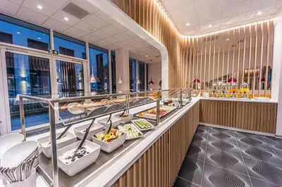a buffet line with plates of food in a restaurant at Prize by Radisson, Antwerp City in Antwerp