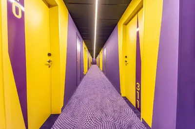 a hallway with purple and yellow walls and a purple mattress at Prize by Radisson, Antwerp City in Antwerp