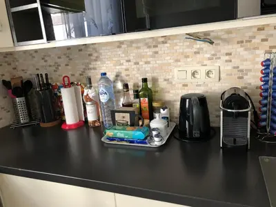 a black counter top with a coffee maker and alcohol at Appartement Chez Agnes in Brussels