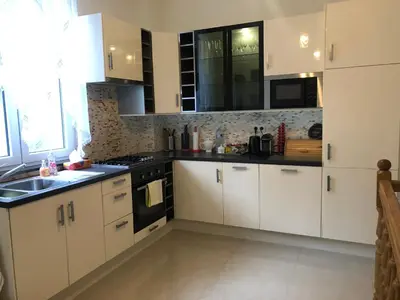 a kitchen with white cabinets and black appliances at Appartement Chez Agnes in Brussels