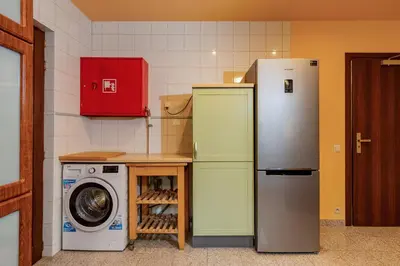 a kitchen with a refrigerator and a washing machine at La Hacienda in Vilvoorde