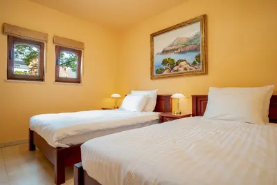 two beds in a room with two windows at La Hacienda in Vilvoorde
