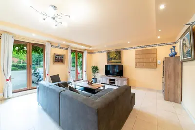 a living room with a couch and a tv at La Hacienda in Vilvoorde