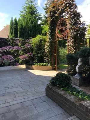 an archway in a garden with flowers and plants at T klein Kasteeltje Wetteren in Wetteren