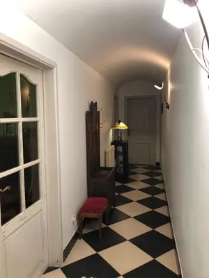a hallway with a checkered floor and a door at T klein Kasteeltje Wetteren in Wetteren