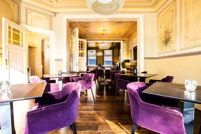 a restaurant with purple chairs and tables at Villa Tilia in Retie