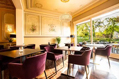 a restaurant with tables and chairs and a large window at Villa Tilia in Retie