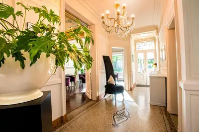 a hallway with a potted plant and a chandelier at Villa Tilia in Retie