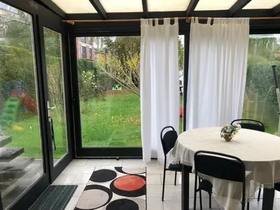 a dining room with a table and a large window at Residence Lilac in Brussels