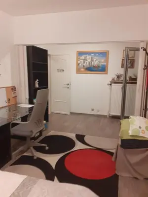 a living room with a desk and a chair and a table at Residence Lilac in Brussels