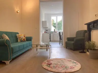 a living room with a green couch and a table at Dreamland Apartments EU, Brussels in Brussels