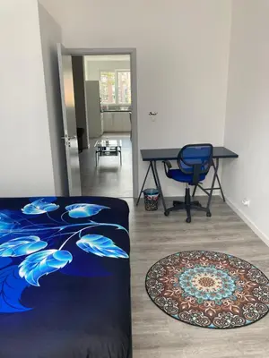 a room with a desk and a bed and a chair at Dreamland Apartments EU, Brussels in Brussels