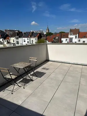 a table and two chairs on a roof at Dreamland Apartments EU, Brussels in Brussels