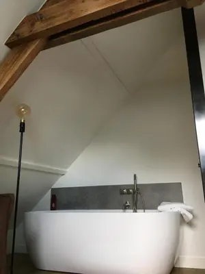 a large white bath tub in a attic at B&B Sint-Mariaburg in Antwerp