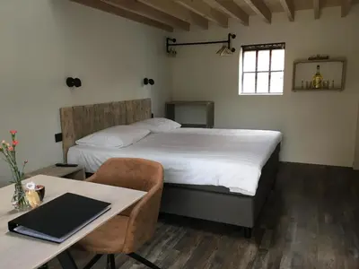 a bedroom with a bed and a desk with a laptop at B&B Sint-Mariaburg in Antwerp