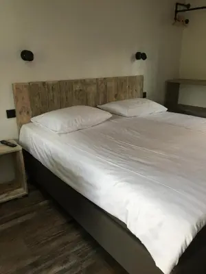 a large bed with white sheets and pillows at B&B Sint-Mariaburg in Antwerp