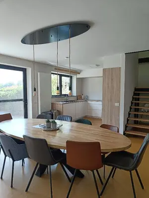 a dining room and kitchen with a wooden table and chairs at HYTTA in Arendonk
