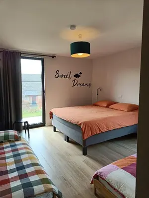 a bedroom with two beds and a sign that reads sweet dreams at HYTTA in Arendonk