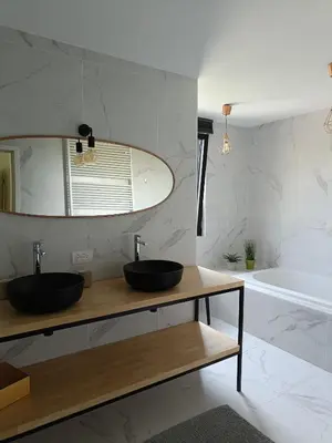 a bathroom with two sinks and a tub at HYTTA in Arendonk