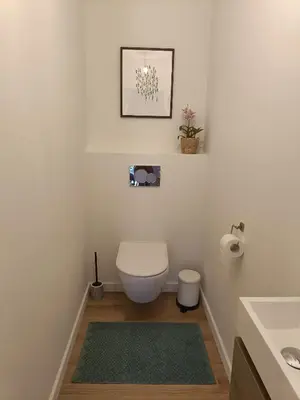 a white bathroom with a toilet and a sink at HYTTA in Arendonk