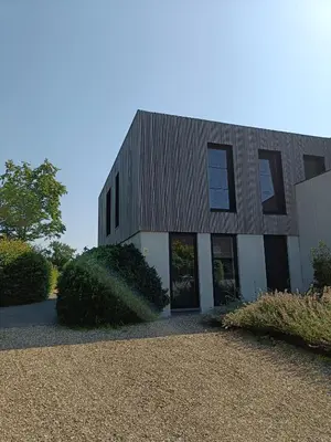a black and white building with a gravel driveway at HYTTA in Arendonk