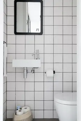 a white tiled bathroom with a sink and a toilet at MAISON12 - Design apartments with terrace and view over Ghent towers in Ghent