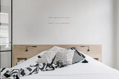 a bed with black and white pillows on it at MAISON12 - Design apartments with terrace and view over Ghent towers in Ghent