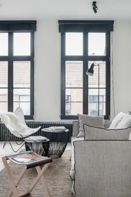 a living room with a couch and chairs and windows at MAISON12 - Design apartments with terrace and view over Ghent towers in Ghent