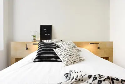 a bed with black and white pillows on it at MAISON12 - Design apartments with terrace and view over Ghent towers in Ghent