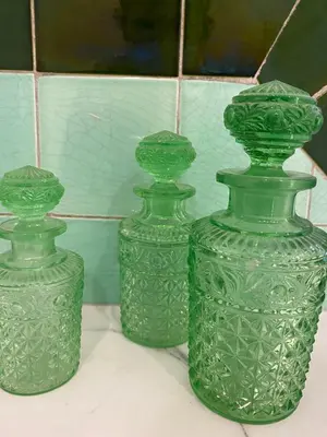 three green glass vases sitting on a table at Nova Zembla in Mechelen
