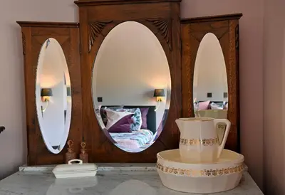 a bathroom with three mirrors and a tub in a room at Nova Zembla in Mechelen