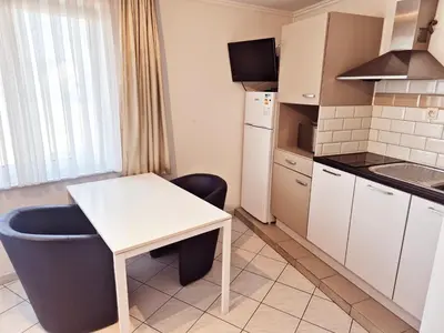 a small kitchen with a white table and a chair at Flatpolis Brussels Airport Budget in Diegem