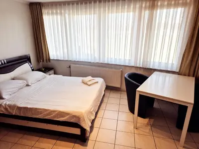 a bedroom with a bed and a desk and a table at Flatpolis Brussels Airport Budget in Diegem